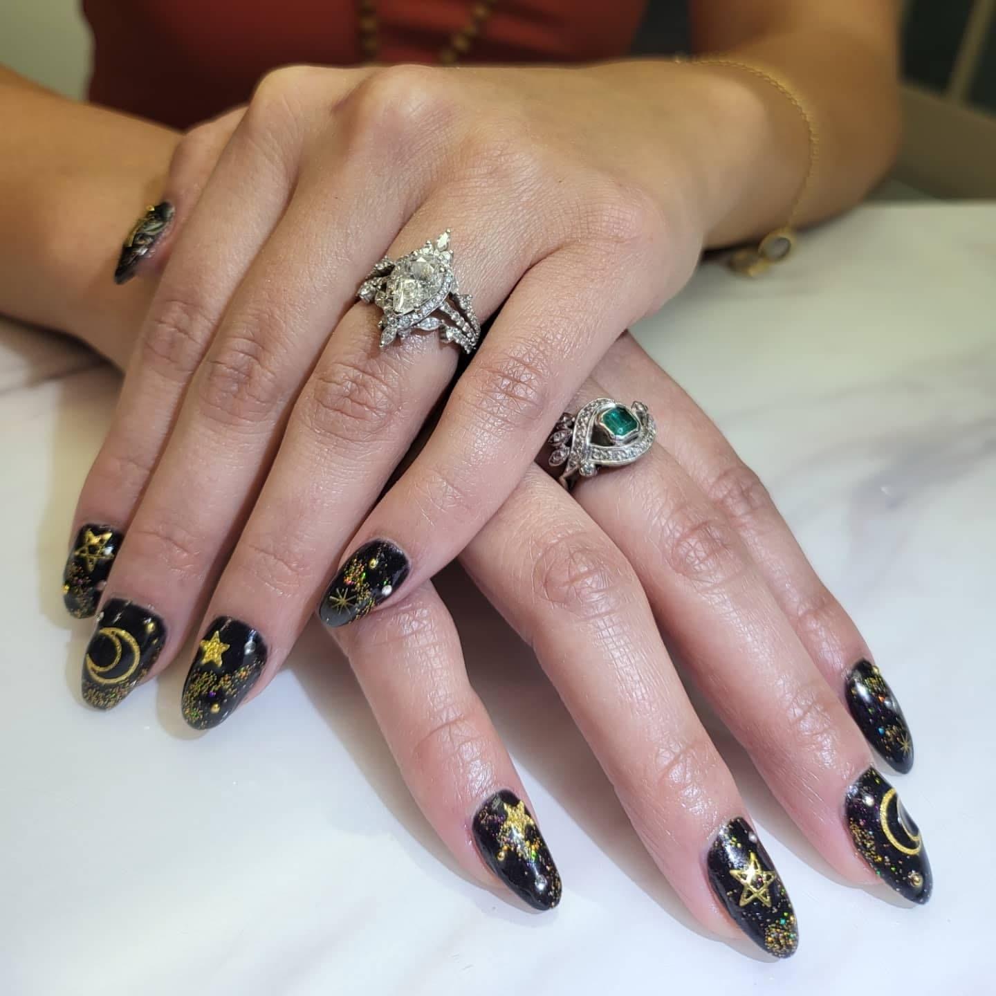 Black celestial nails with gold stars and moons — Allegro Nail Parlour
