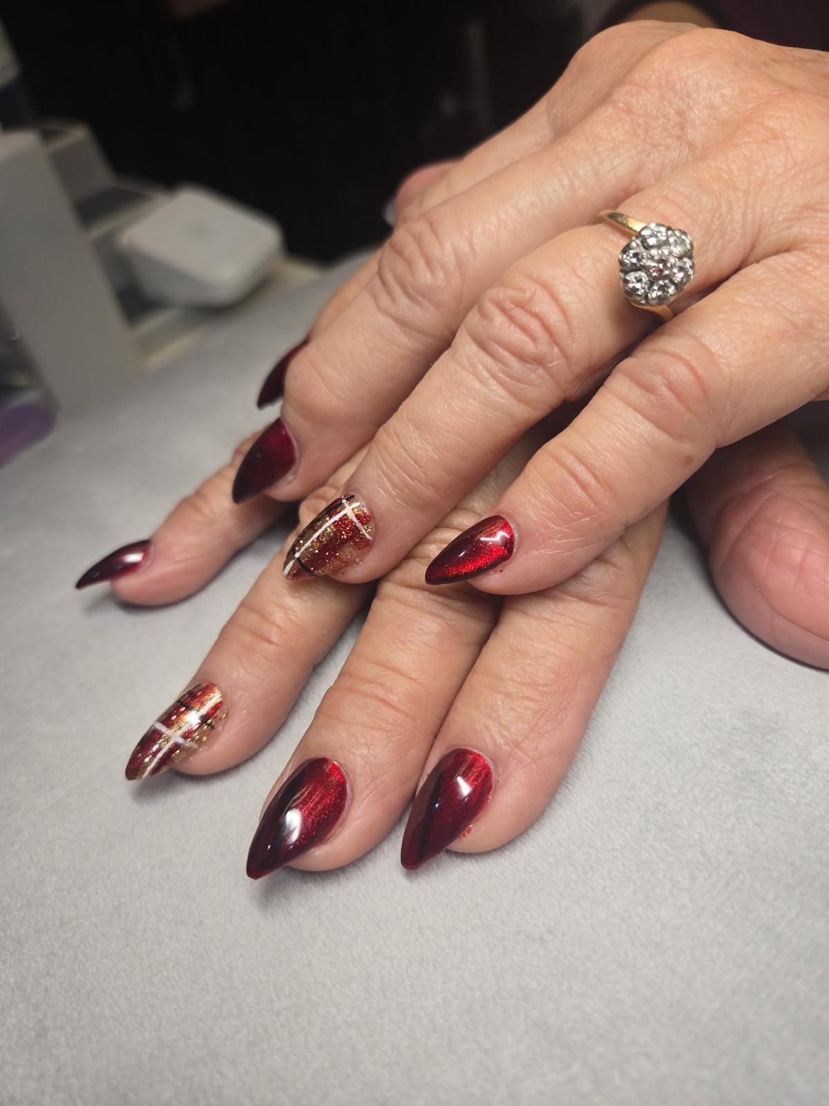 Red metallic stiletto nails with gold French tip accent — Allegro El Paso